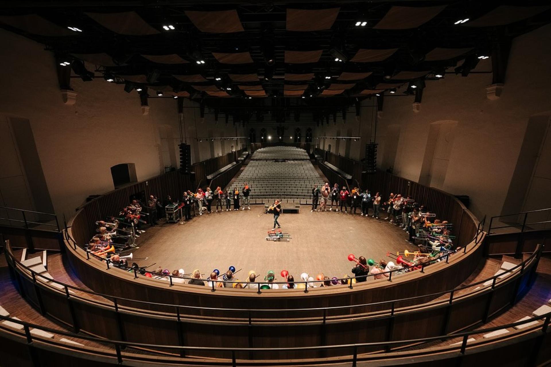 Grote muzikale teambuilding in een concertzaal met deelnemers