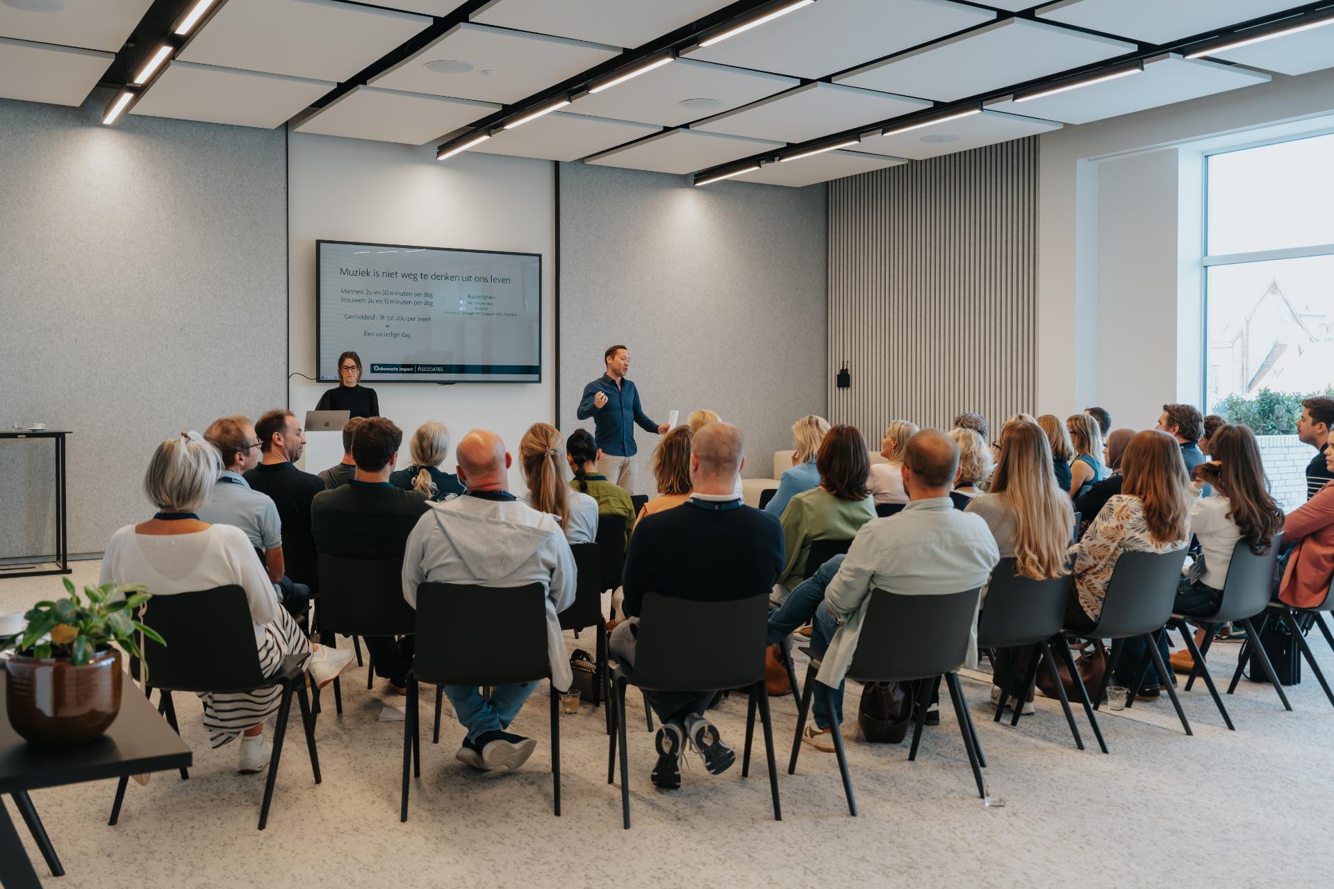 Publiek luistert naar Kaat en Pieter tijdens de keynote Muziek en het brein van De Muzieksommelier