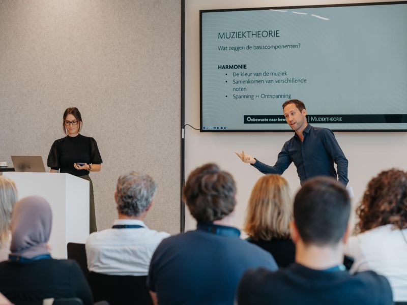 Kaat en Pieter van De Muzieksommelier tijdens een keynote over muziek voor bedrijven